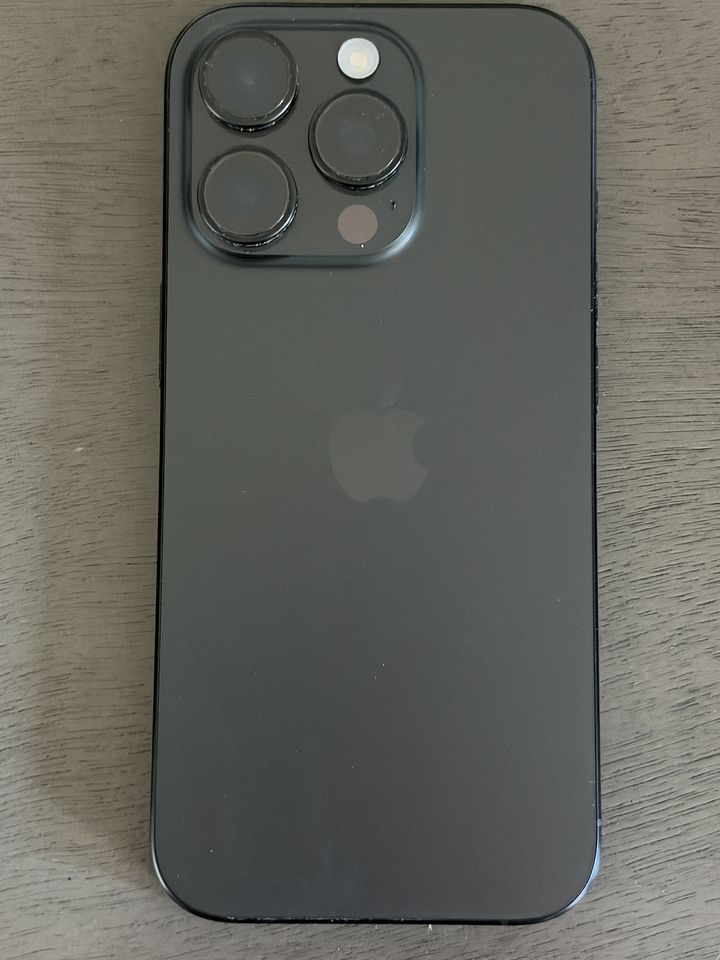 Tył iPhone’a 16 Pro w kolorze tytanu czarnego z potrójnym aparatem