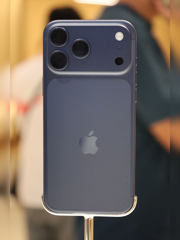 Tył iPhone’a 17 Pro Max w kolorze ciemnoniebieskim (Deep Blue) na stojaku