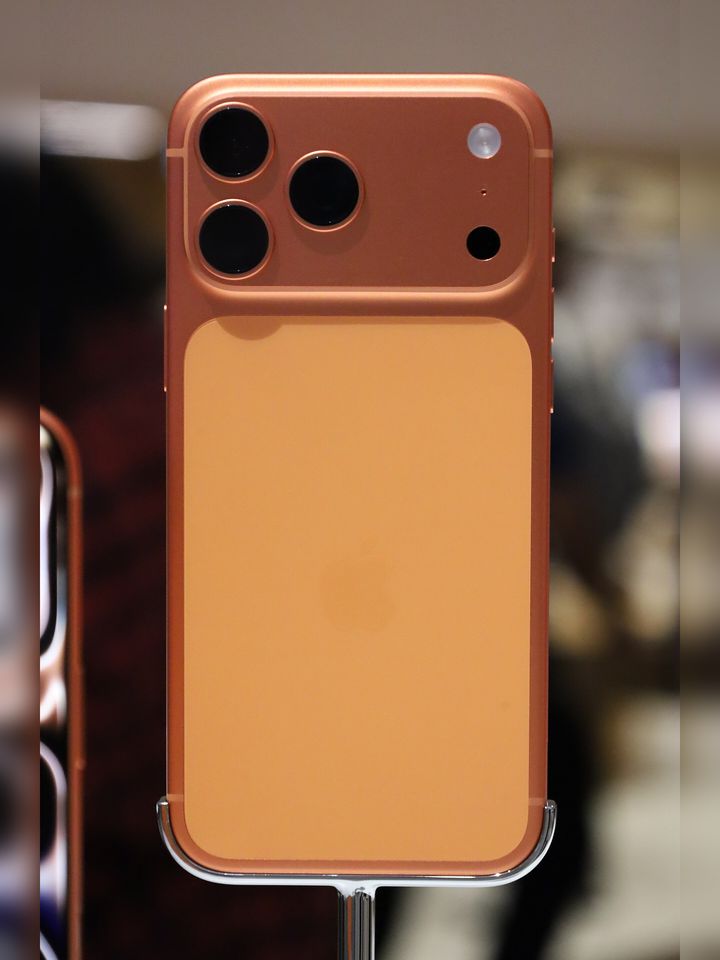 Tył iPhone’a 17 Pro Max w kolorze pomarańczowym (Cosmic Orange) na stojaku